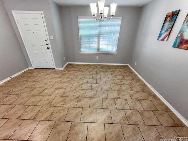 interior space with baseboards and a chandelier