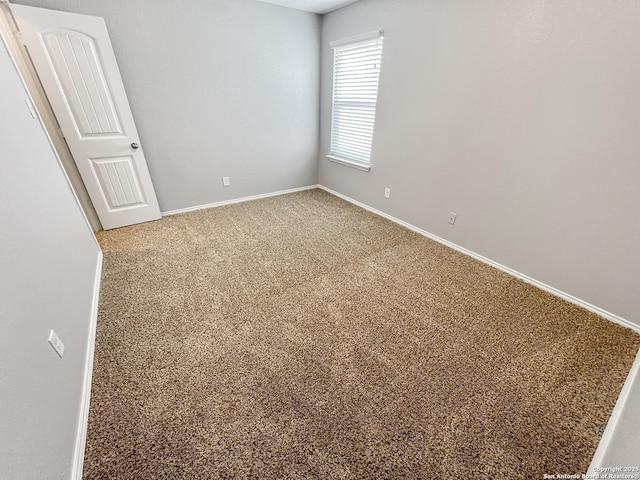 unfurnished room with carpet flooring and baseboards