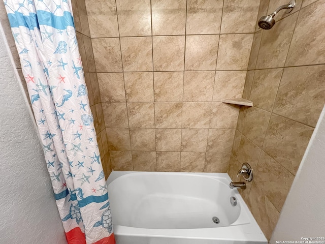 bathroom featuring a textured wall and shower / tub combo