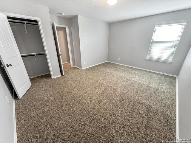 unfurnished bedroom with carpet floors, baseboards, and a closet