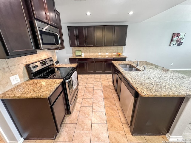 kitchen with a sink, light stone counters, backsplash, and stainless steel appliances