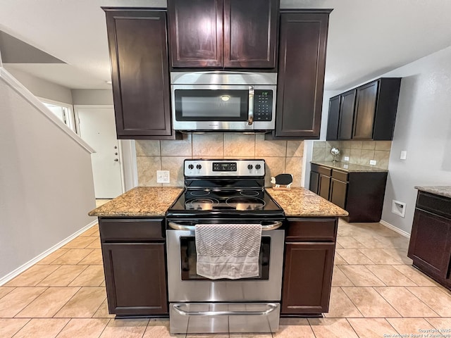 kitchen featuring appliances with stainless steel finishes, tasteful backsplash, light tile patterned floors, baseboards, and light stone counters