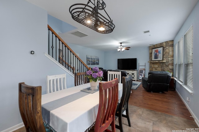 dining area featuring visible vents, a ceiling fan, baseboards, and stairway