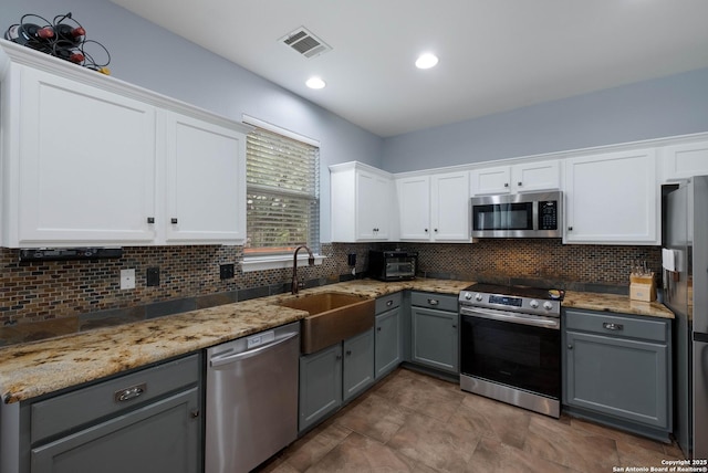 kitchen with visible vents, tasteful backsplash, a sink, appliances with stainless steel finishes, and gray cabinetry