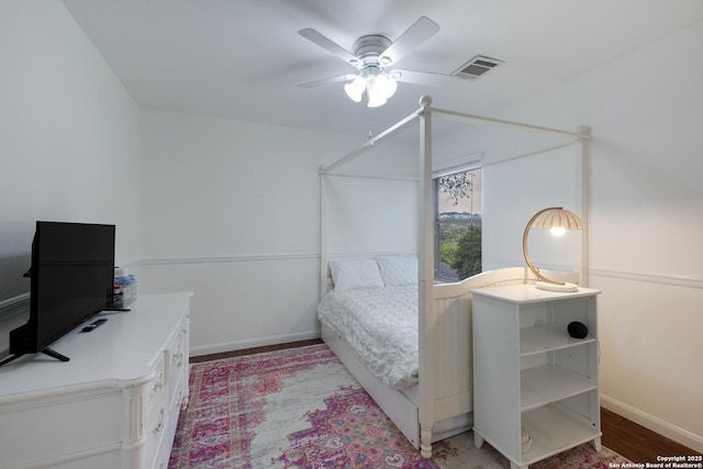 bedroom featuring baseboards, a ceiling fan, wood finished floors, and visible vents