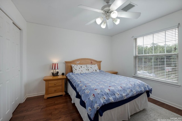 bedroom featuring baseboards, a closet, wood finished floors, and visible vents