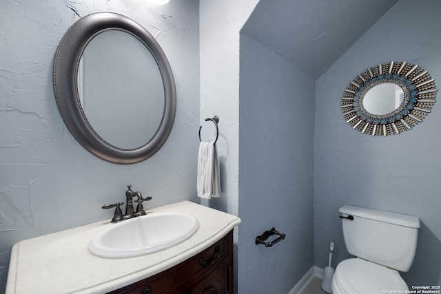 half bathroom featuring vanity and toilet