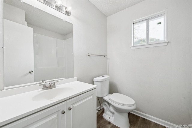 full bathroom with a textured ceiling, walk in shower, wood finished floors, vanity, and toilet
