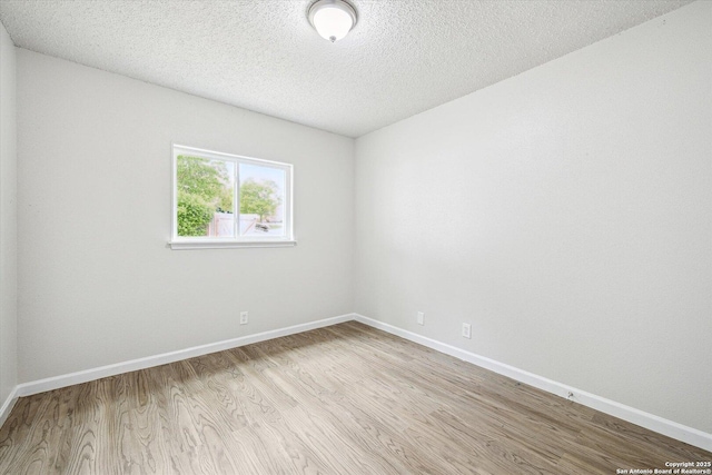 unfurnished room featuring baseboards, a textured ceiling, and wood finished floors