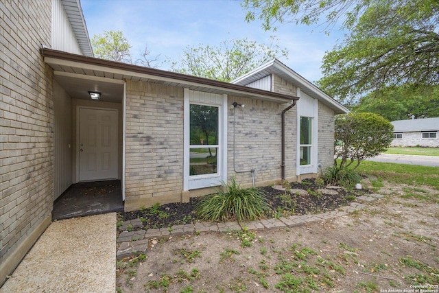 entrance to property featuring brick siding