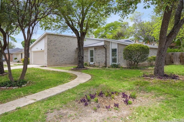 mid-century home with brick siding, a garage, a front lawn, and driveway