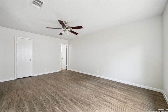 unfurnished room featuring baseboards, ceiling fan, visible vents, and wood finished floors