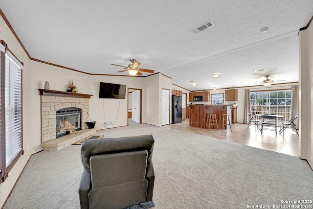 769 Kristen Ln, Harper, TX 78631 - living room featuring visible vents, crown molding, a brick fireplace, light carpet, and ceiling fan