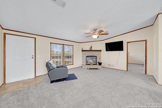 769 Kristen Ln, Harper, TX 78631 - unfurnished living room featuring crown molding, carpet flooring, ceiling fan, a glass covered fireplace, and visible vents