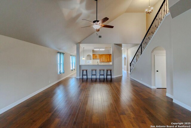 26923 Trinity Hts, San Antonio, TX 78261 - living area featuring arched walkways, stairway, high vaulted ceiling, ceiling fan with notable chandelier, and dark wood-style floors