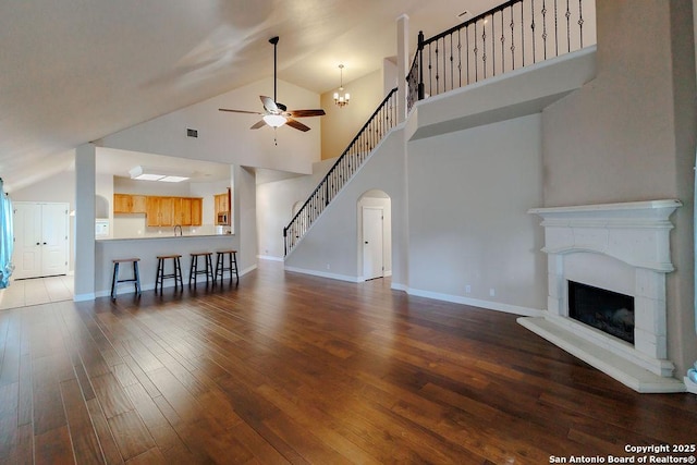 26923 Trinity Hts, San Antonio, TX 78261 - unfurnished living room with ceiling fan, visible vents, hardwood / wood-style flooring, a fireplace with raised hearth, and stairs