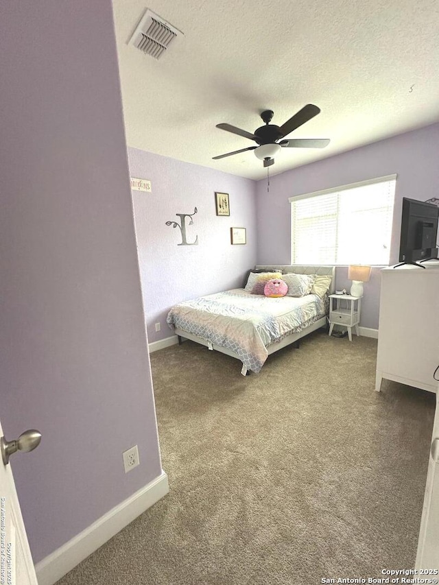 carpeted bedroom featuring visible vents, a textured ceiling, and baseboards