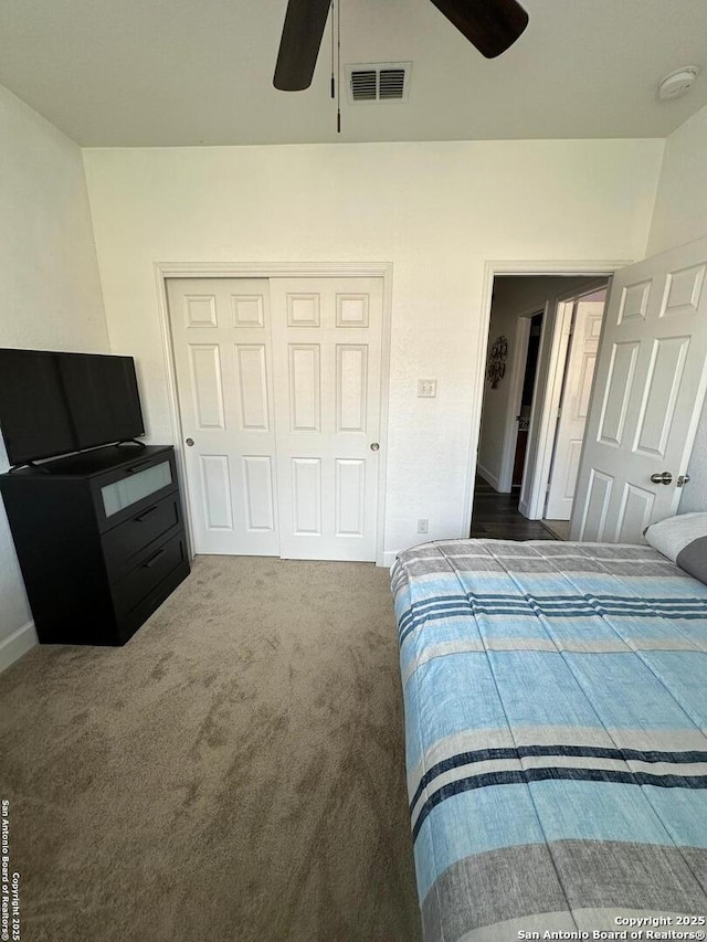 carpeted bedroom with visible vents, baseboards, ceiling fan, and a closet