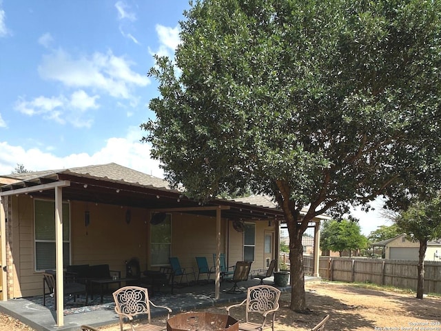 rear view of property featuring fence, outdoor lounge area, and a patio area