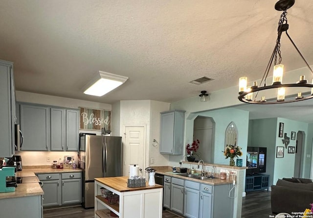 kitchen with butcher block countertops, gray cabinets, dark wood-type flooring, and stainless steel appliances