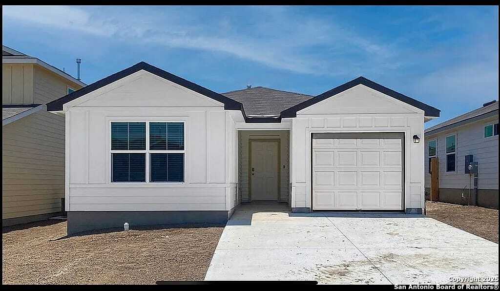 ranch-style house featuring a garage, board and batten siding, and concrete driveway