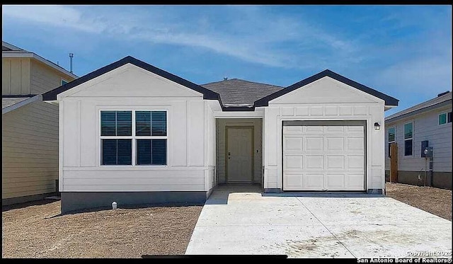 ranch-style house featuring a garage, board and batten siding, and concrete driveway