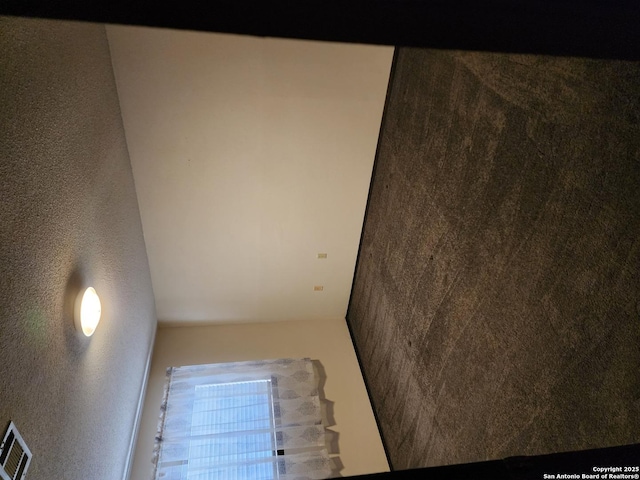 empty room featuring visible vents and a textured wall