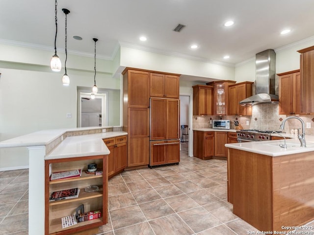 13907 Bluffmont, San Antonio, TX 78216 - kitchen featuring visible vents, a peninsula, wall chimney range hood, high quality appliances, and brown cabinets
