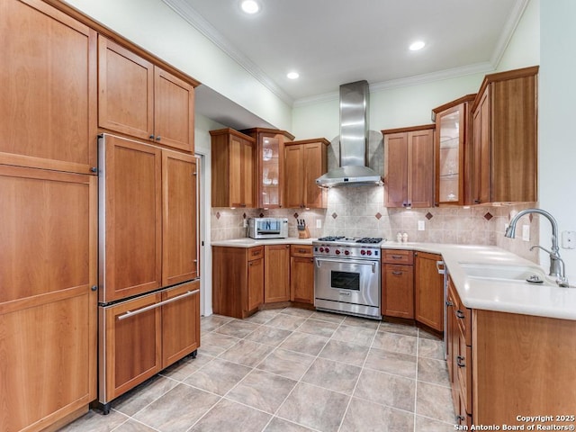 13907 Bluffmont, San Antonio, TX 78216 - kitchen with brown cabinetry, crown molding, wall chimney range hood, a sink, and premium appliances
