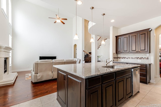 2623 Galit Cv, San Antonio, TX 78230 - kitchen featuring arched walkways, ceiling fan, a glass covered fireplace, and a sink