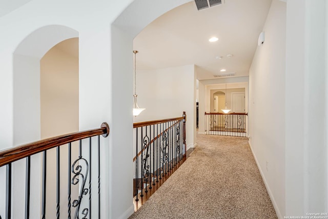 2623 Galit Cv, San Antonio, TX 78230 - hallway with carpet flooring, arched walkways, visible vents, and an upstairs landing