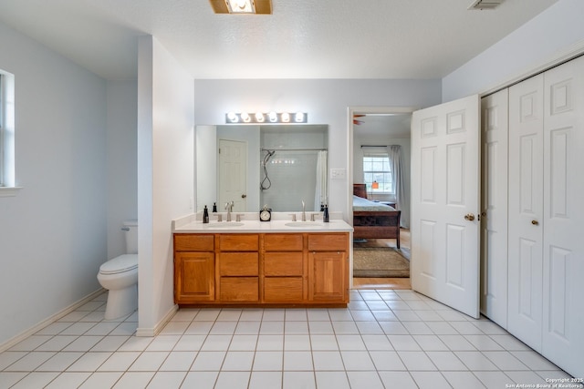 full bathroom featuring double vanity, toilet, a shower stall, and a sink