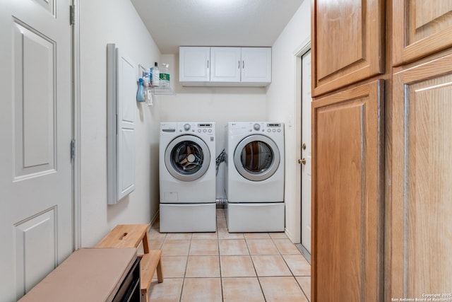 laundry area with cabinet space, independent washer and dryer, and light tile patterned flooring