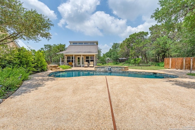 outdoor pool with an outbuilding, a patio area, fence, and a storage structure