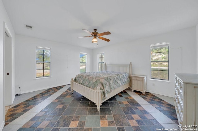bedroom with visible vents, baseboards, and multiple windows