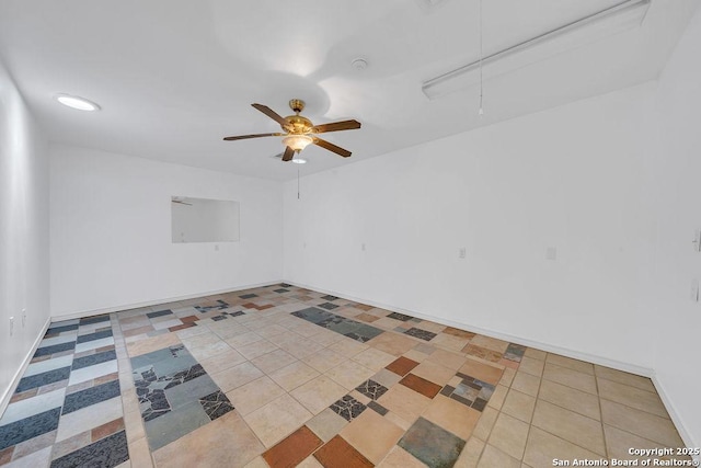 tiled spare room featuring baseboards, a ceiling fan, and attic access