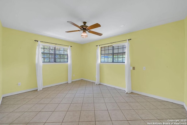 unfurnished room with baseboards, ceiling fan, and a healthy amount of sunlight