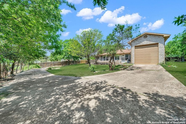 single story home featuring a garage, fence, a front yard, brick siding, and concrete driveway