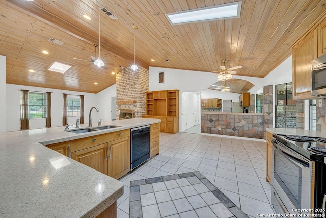 kitchen with open floor plan, black dishwasher, vaulted ceiling with skylight, a sink, and stainless steel range with electric cooktop