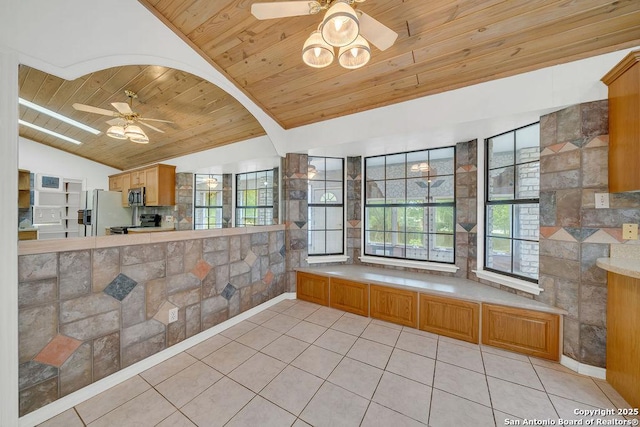 interior space featuring lofted ceiling, light tile patterned flooring, plenty of natural light, wood ceiling, and a ceiling fan