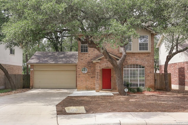traditional-style house with concrete driveway, brick siding, fence, and a garage