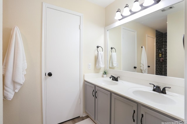 bathroom featuring visible vents, a sink, and double vanity