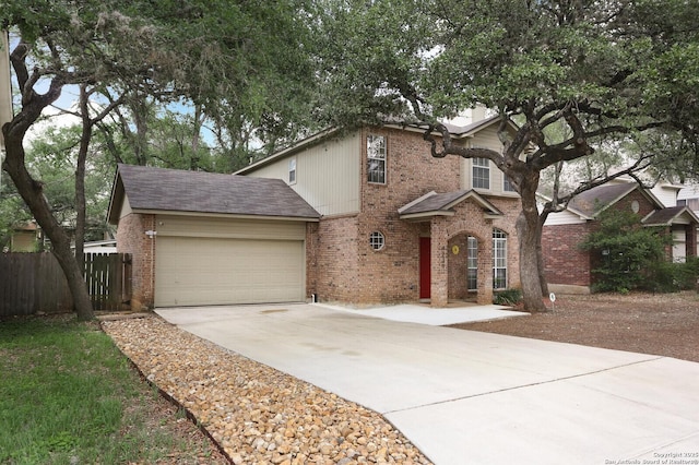 traditional-style home with concrete driveway, brick siding, an attached garage, and fence