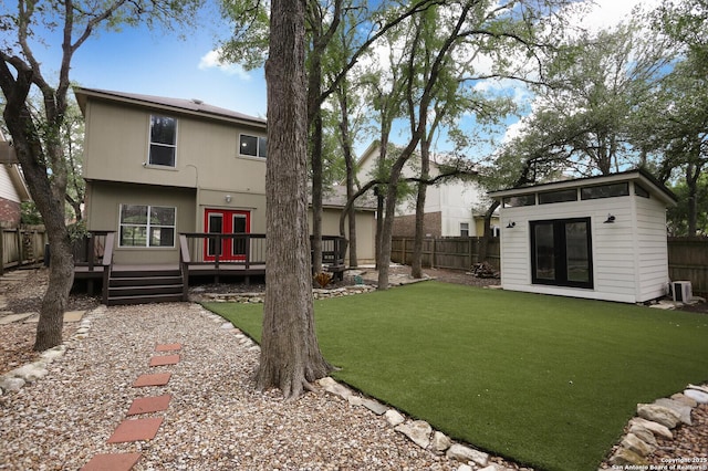 view of yard featuring french doors, a wooden deck, central AC unit, an outdoor structure, and a fenced backyard