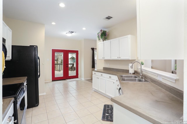 kitchen with visible vents, electric range, white cabinets, a sink, and light tile patterned floors