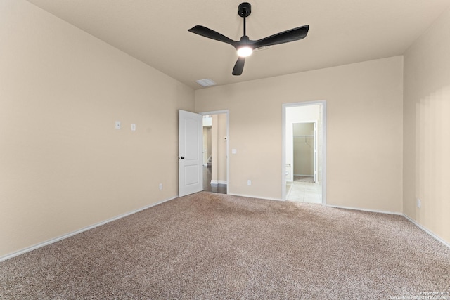 unfurnished bedroom featuring a ceiling fan, light colored carpet, visible vents, baseboards, and ensuite bath