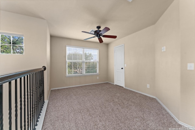 carpeted spare room with a ceiling fan, baseboards, and a healthy amount of sunlight