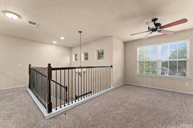 interior space featuring carpet floors, ceiling fan, visible vents, and baseboards