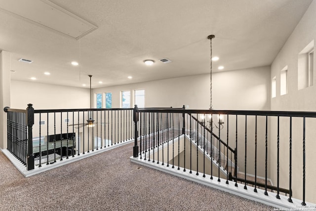 hall with attic access, visible vents, carpet floors, an upstairs landing, and recessed lighting