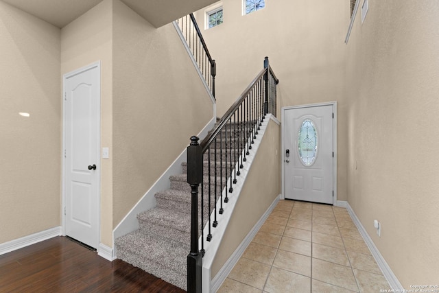 entryway featuring a healthy amount of sunlight, baseboards, and stairs